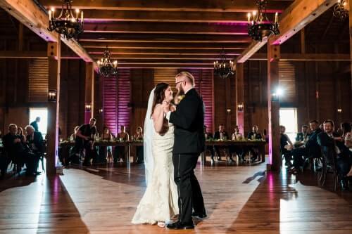 Harrisburg-Wedding-Spotlights Couple sharing their first dance on an empty dance floor at Harrisburg venue with purple and white spotlights