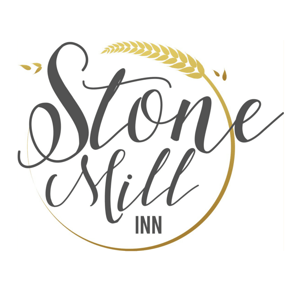 Logo for Stone Mill Inn with stylized cursive text and a golden wheat stalk arching above the words.
