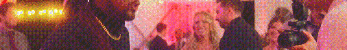 klock-hero-text-bkgd-128 People are socializing and posing for photos at a party or event with pink ambient lighting and a lively atmosphere.