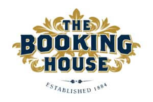 venue-logo-booking-house Logo for The Booking House with gold decorative accents and the text "THE BOOKING HOUSE" in bold, navy letters above "ESTABLISHED 1884.