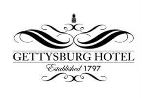 venue-logo-gettysburg-hotel Black and white logo for Gettysburg Hotel with decorative flourishes, a small pineapple at the top, and the text "Established 1797" below the hotel name.