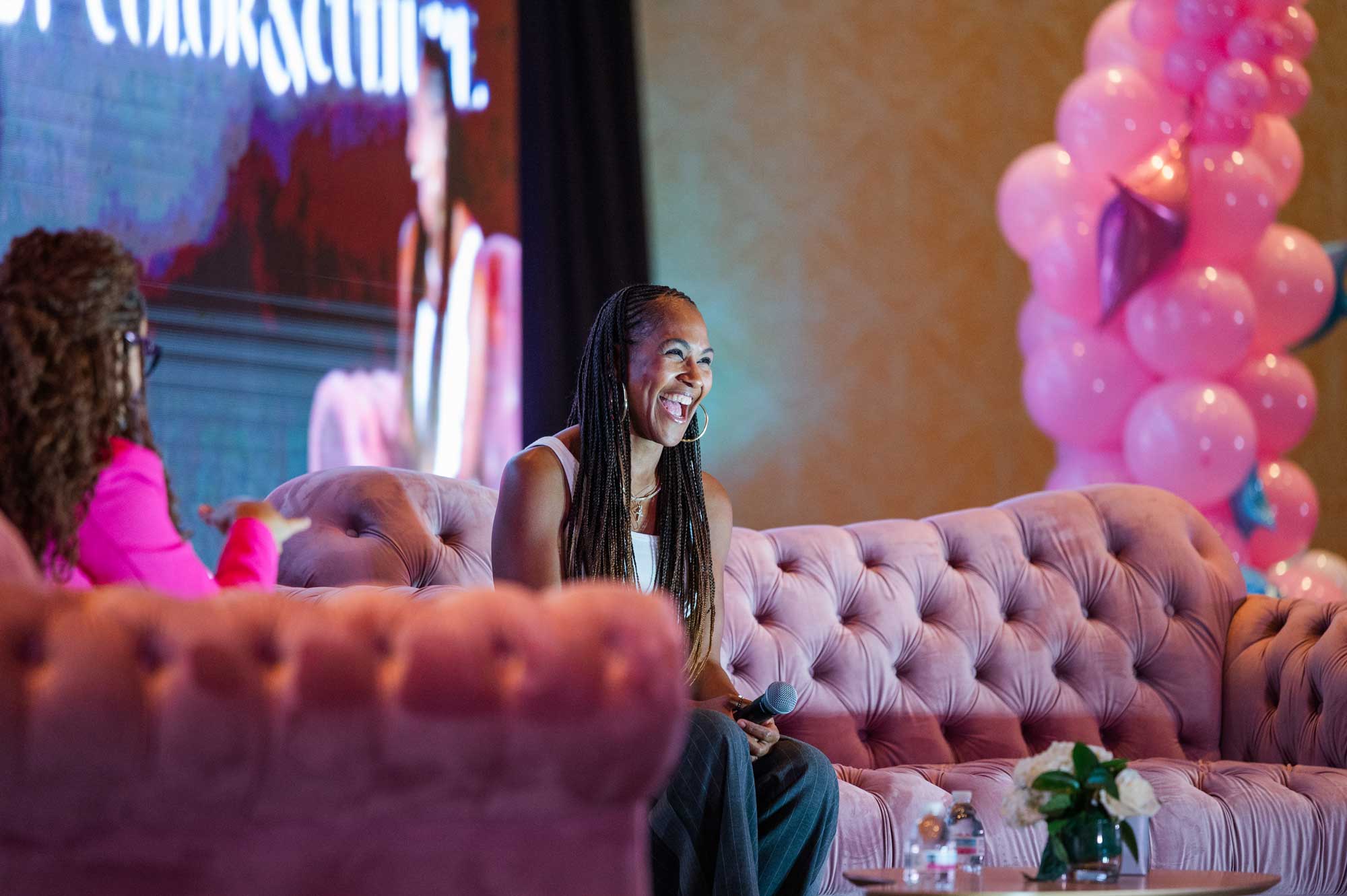 A speaker smiling on stage at the Maternal Summit