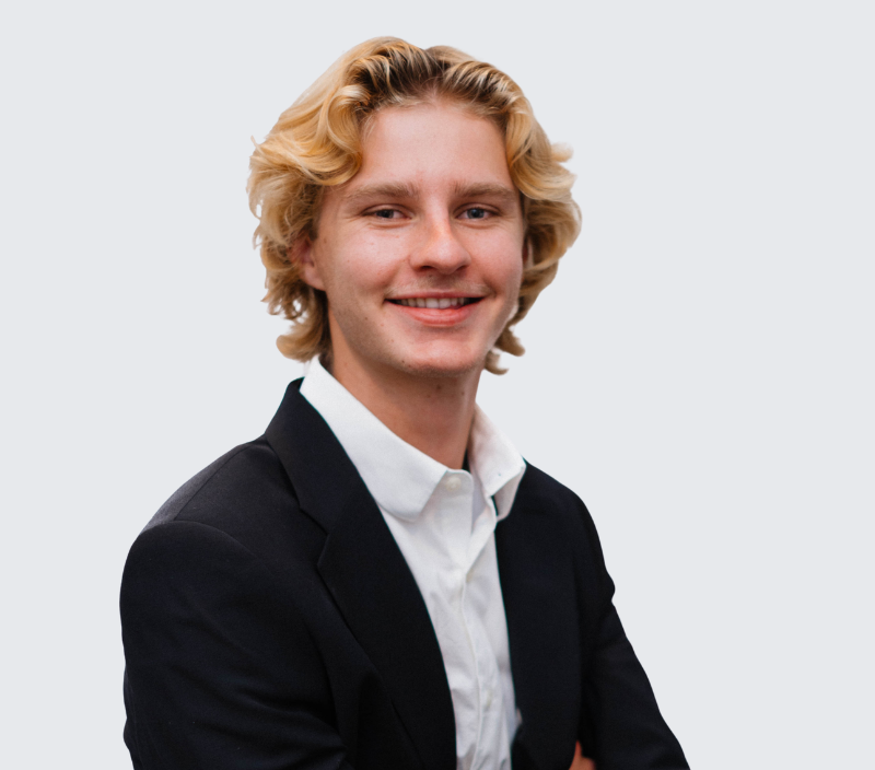 Luke-26 A smiling young man with blonde hair wearing a black blazer and white shirt.